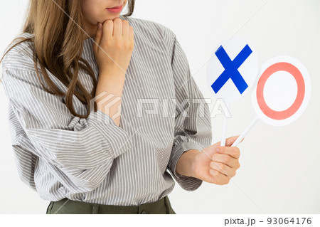 丸ばつプレートを持つ若い女性 丸ばつプレートを持つ若い女性 93064176