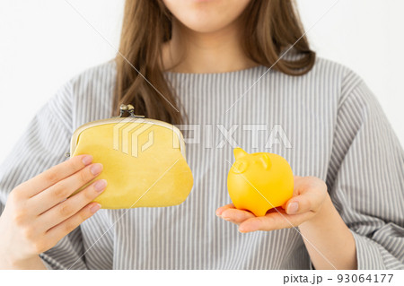豚の貯金箱を持つ若い女性 豚の貯金箱を持つ若い女性 93064177