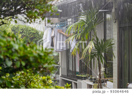 民家に叩きつける豪雨　慌てて洗濯物を取り込む主婦　 93064646