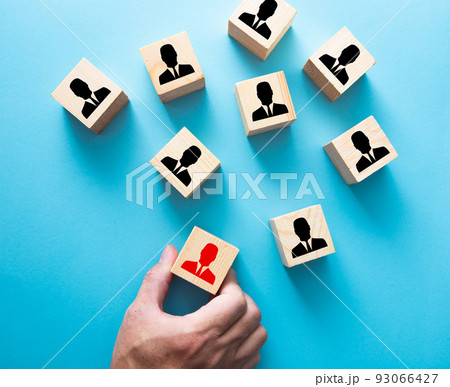 Employment choice concept. Hand choosing a wooden person block from a set. 93066427