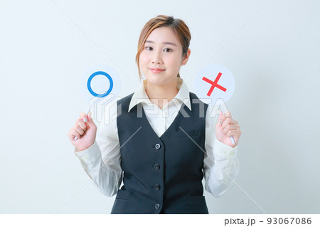 ○✖プレートを持って微笑む若いOL 93067086