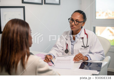 Confident doctor showing agreement to female patient in clinic Confident doctor showing agreement to female patient in clinic 93068338