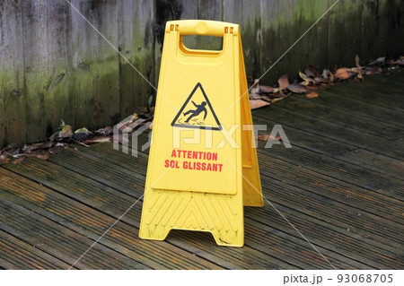 Caution slippery floor surface sign called attention sol glissant in french language 93068705