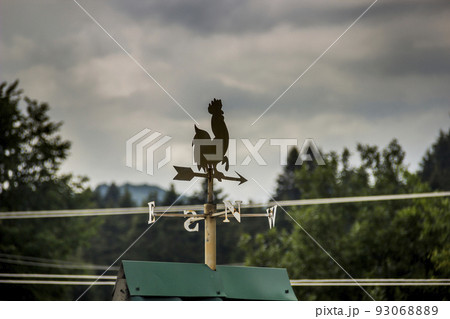 a weathercock on the top of the roof a weathercock on the top of the roof 93068889