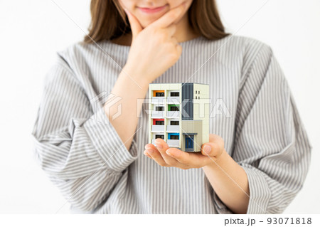 マンションの模型を持つ若い女性 93071818