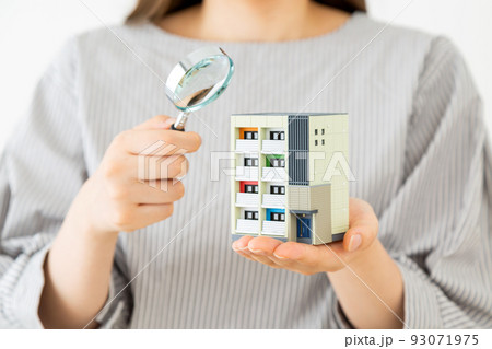 マンションの模型を持つ若い女性 93071975