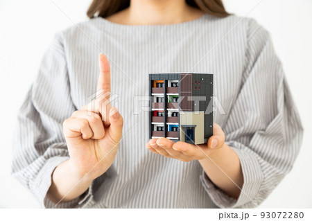 マンションの模型を持つ若い女性 93072280