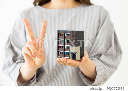 マンションの模型を持つ若い女性 93072281