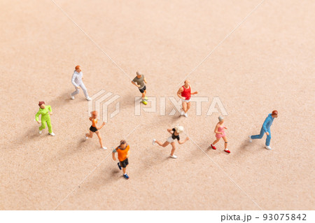 Miniature People exercising while running in a group on the beach 93075842
