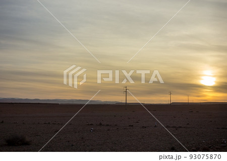 乾燥した荒涼とした土地に沈みゆく太陽　モロッコの街マラケッシュの郊外にて 93075870