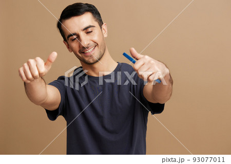 Cheerful man with a phone in hand in a gray T-shirt and glasses tin hands cropped view Cheerful man with a phone in hand in a gray T-shirt and glasses tin hands cropped view 93077011