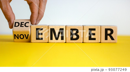 Symbol for the change from November to December. Male hand flips wooden cubes and changes the inscription 'november' to 'december'. Beautiful yellow table, white background, copy space. Symbol for the change from November to December. Male hand flips wooden cubes and changes the inscription 'november' to 'december'. Beautiful yellow table, white background, copy space. 93077249