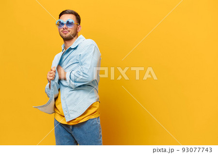 Overjoyed tanned handsome man in blue shirt trendy sunglasses dance sing posing isolated on orange yellow studio background. Copy space Banner Mockup. Relax time Party concept Overjoyed tanned handsome man in blue shirt trendy sunglasses dance sing posing isolated on orange yellow studio background. Copy space Banner Mockup. Relax time Party concept 93077743