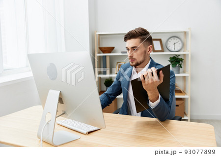 businessmen writes in documents at the desk in the office Gray background 93077899