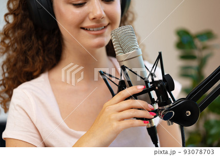 Portrait of happy young female radio host broadcasting in studio 93078703