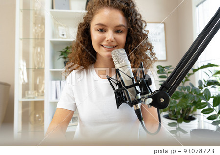 Portrait of happy young female radio host broadcasting in studio 93078723