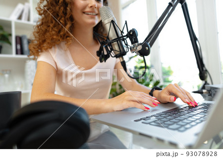 Portrait of happy young female radio host broadcasting in studio 93078928