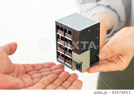 マンションの模型を持つ若い男女 93078953