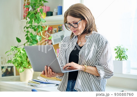 Mature beautiful woman with laptop at home Mature beautiful woman with laptop at home 93080760