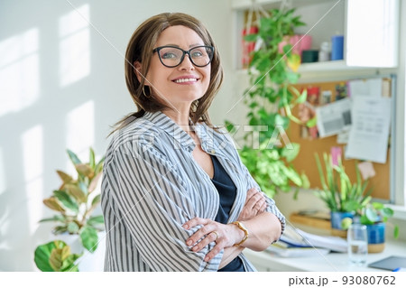 Portrait of confident mature woman looking at camera at home 93080762