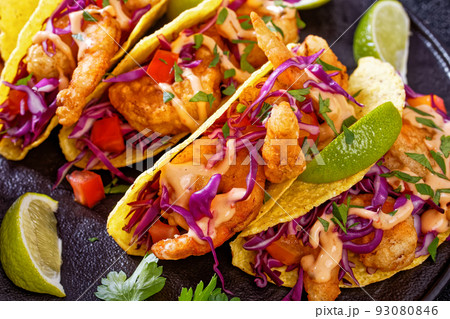 Bang Bang Shrimp Tacos on black plate with sauce 93080846