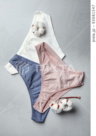Comfortable women's underwear and cotton flowers on light grey stone background, flat lay 93081547