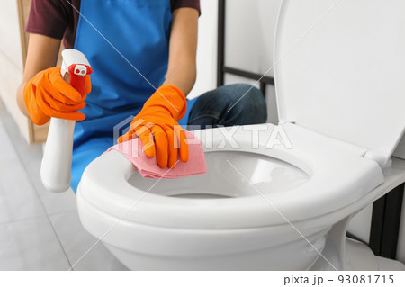 Woman cleaning toilet bowl in bathroom, closeup Woman cleaning toilet bowl in bathroom, closeup 93081715