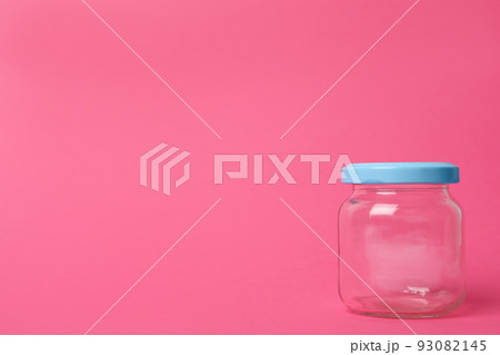 Closed empty glass jar on pink background, space for text Closed empty glass jar on pink background, space for text 93082145