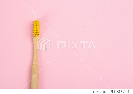 Toothbrush made of bamboo on pink background, top view. Space for text Toothbrush made of bamboo on pink background, top view. Space for text 93082211