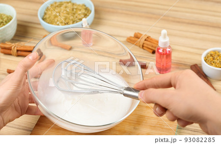 Woman making natural handmade soap at wooden table, closeup 93082285