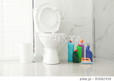Toilet bowl and cleaning supplies in modern bathroom 93082456