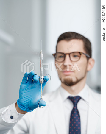 Closeup shot of syringe in hands of a male doctor Closeup shot of syringe in hands of a male doctor 93082669