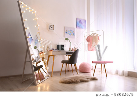 Large mirror with light bulbs in stylish room interior 93082679