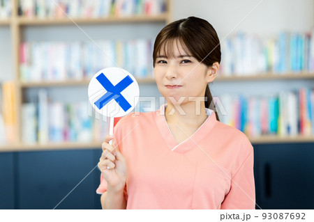 NGのプレートを出す看護師の女性 93087692