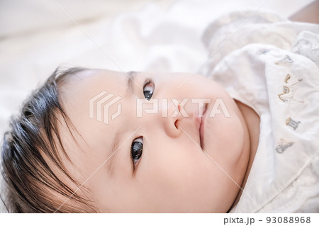 寝返りをしようと頑張る新生児 93088968