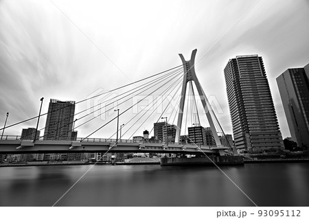 モノクローム長時間露光　long exposure画像　東京隅田川の流れと中央大橋　川沿いの高層ビル 93095112
