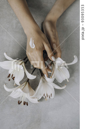 beauty delicate hands with manicure holding flower lily close up on a gray concrete. Moisturizing cream for clean and soft skin. Love a body. Healthcare concept. beauty delicate hands with manicure holding flower lily close up on a gray concrete. Moisturizing cream for clean and soft skin. Love a body. Healthcare concept. 93095353