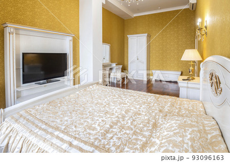 Bedroom with a large bed and a TV in front of it 93096163
