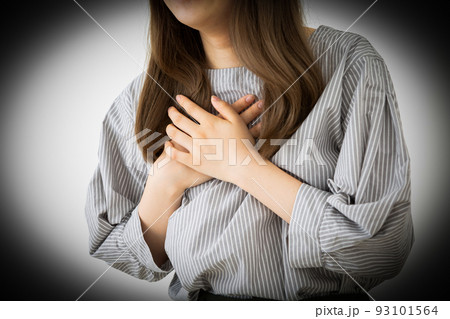 胸を押さえて苦しむ若い女性 93101564