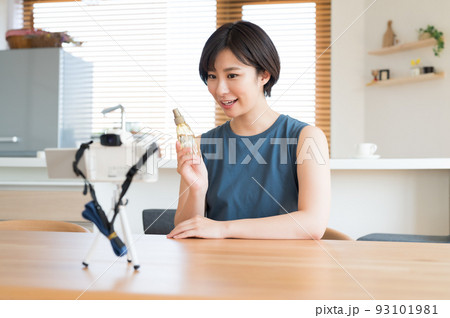 カメラの前でお勧め化粧品の動画を収録する女性 カメラの前でお勧め化粧品の動画を収録する女性 93101981