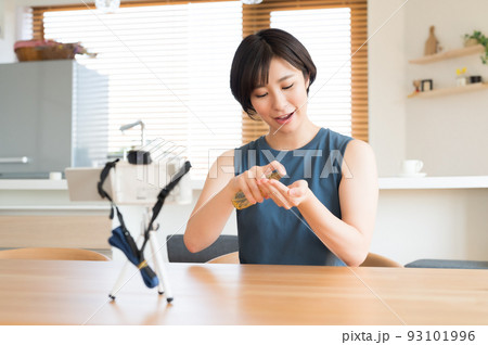 カメラの前でお勧め化粧品の動画を収録する女性 カメラの前でお勧め化粧品の動画を収録する女性 93101996