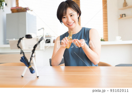 カメラの前でお勧め化粧品の動画を収録する女性 カメラの前でお勧め化粧品の動画を収録する女性 93102011