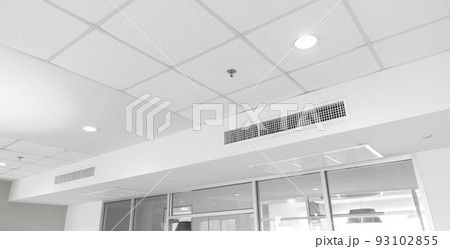 Ceiling mounted cassette type air conditioner and modern lamp light on white ceiling. duct air conditioner for home or office Ceiling mounted cassette type air conditioner and modern lamp light on white ceiling. duct air conditioner for home or office 93102855
