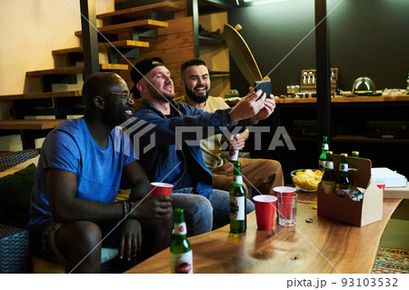 Three happy young intercultural buddies making selfie on smartphone 93103532