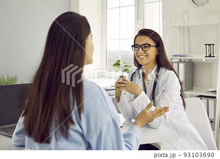 Friendly female doctor listening to her female patient at consultation meeting in hospital office. 93103690