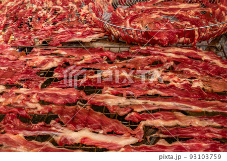 Dried meat slices on a steel grill Dried meat slices on a steel grill 93103759