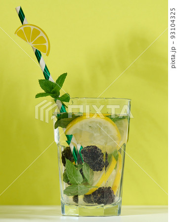 Transparent glass with lemonade, mint leaves, lemon slices and blackberries Transparent glass with lemonade, mint leaves, lemon slices and blackberries 93104325