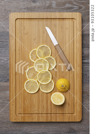 Juicy lemons cut into slices on a kitchen board 93105322