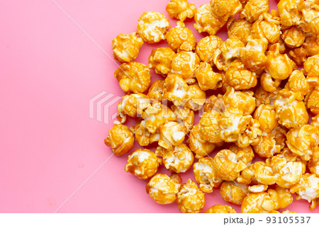 Honey caramel popcorn on pink background. Honey caramel popcorn on pink background. 93105537