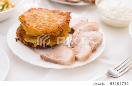 Fried grated potato pancakes with meat on white plate Fried grated potato pancakes with meat on white plate 93105756